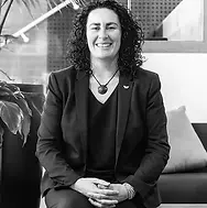 Black and white image of Jane sitting down with her arms folded in her lap